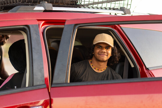 teen boy looking through car window sitting in back seat