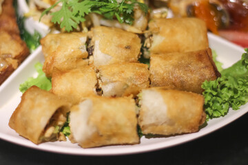 Deep fried vegetable spring roll in white plate on wood table vegan food background