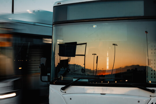 Public transport buses at the Sydney Domestic Airport with reflection of sunset in windscreen