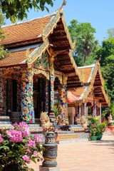 Obraz premium Colorful Temple Facade with Intricate Decorations and Flowers in Thailand