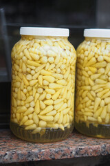 Beautifully Arranged Jars Filled with Pickled Yellow Garlic Cloves are on Display for All to See