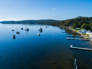 Person recreational boats moored in blue water of Lake Macquarie seen from aerial view