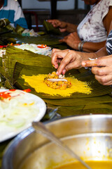 Unrecognizable people in the process of making delicious hallacas food. Traditional christmas dish from Venezuela. Holiday season. Venezuelan culture.