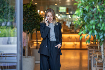Confident woman small business owner have cellphone dialogue negotiates with suppliers. Pleased...