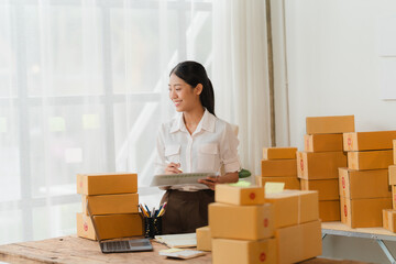 E-Commerce Success: Asian entrepreneur amidst a flurry of packages, diligently managing her thriving online business.