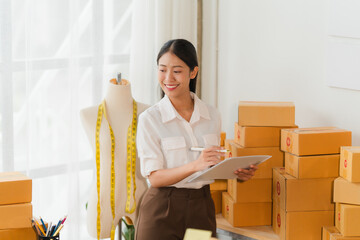 Smiling Entrepreneur: A young Asian woman, confidently working in her home office, surrounded by...