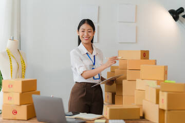 E-commerce Success: Young Asian entrepreneur managing her online business orders in a home office, surrounded by packages and radiating entrepreneurial spirit.  