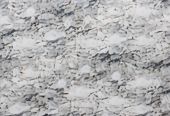 A close-up view of a marble or paper surface featuring intricate veining patterns in shades of white and beige. The texture is smooth and polished.