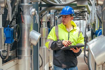 technician carefully inspecting a section of pipeline during a construction project, emphasizing safety and precision in infrastructure development.