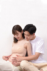 妊娠した若妻に寄り添う若い夫