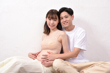 妊娠した若妻に寄り添う若い夫