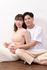 妊娠して大きなお腹の若い妊婦と優しく寄り添う夫