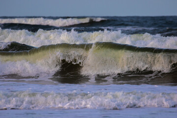 yellowish waves against a blue sky. 