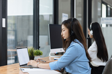 Young asian businesswoman with headset using desktop computer for customer support and online working in office, Call center helping for customers online concept.