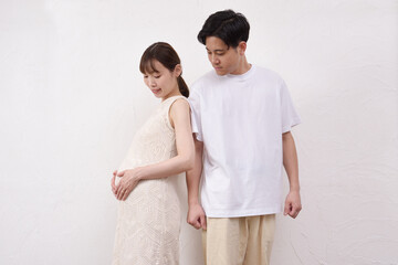 妊娠した大きなお腹の妻に寄り添う夫