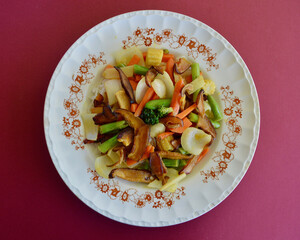 Asian stir fried vegetables featuring Shiitake mushrooms on a bed of long grain rice. 
