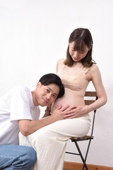 妊娠した若妻と優しく寄り添う若い夫