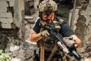 Portrait of air soft soldier with weapon shooting at opponent.