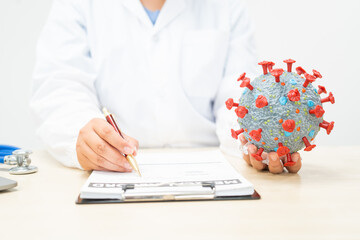 A female doctor sits at a table in a hospital, discussing the COVID-19 virus.She explains the...
