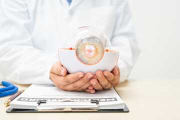 A female doctor at a desk in a hospital, discussing eye diseases such as color blindness,...