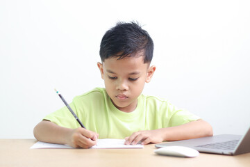 A Happy little asian boy studying online learning class with online video call zoom teacher at home. E-learning or Home schooling education concept.