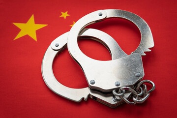 China flag and police handcuffs. The concept of observance of the law in the country and protection...