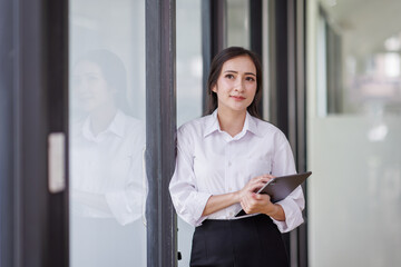 Happy confident asian professional business woman standing at work in office arms crossed looking away, asian businesswoman leader executive thinking of future success.