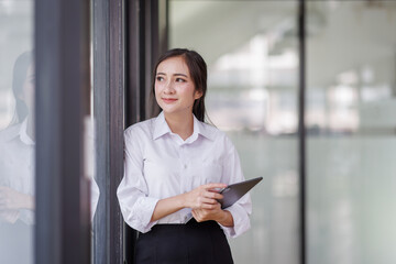 Happy confident asian professional business woman standing at work in office arms crossed looking away, asian businesswoman leader executive thinking of future success.