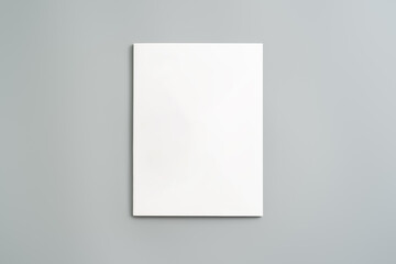 Fototapeta premium Empty White Sheet of Paper Positioned at an Angle on Light Gray Surface