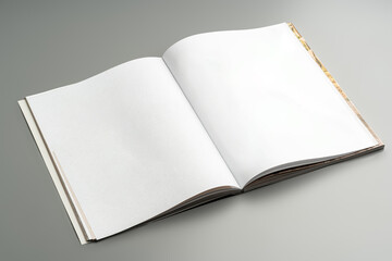 A blank open notebook resting on a neutral background during daylight