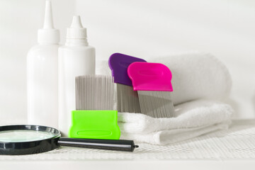 Lice treatment product next to a nit comb and magnifying glass
