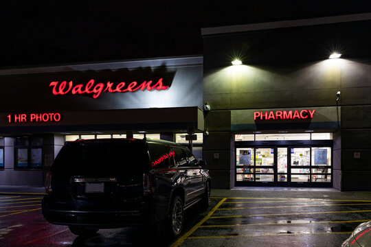 Portland, Oregon- USA -Feb 27, 2024 - American famous Walgreens Pharmacy and Photo store big red glowing logo at night high quality photo for download