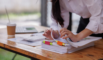 Business colleagues reviewing financial documents and calculating taxes. Auditor inspecting financial reports with magnifying glass. Business audit, taxes and forensic accounting concept
