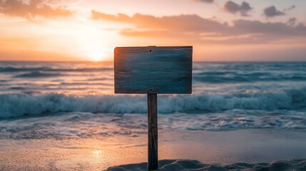 日の出とビーチに立つ木製看板