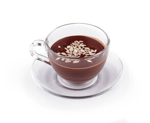 Glass cup containing hot chocolate with sunflower seeds on top