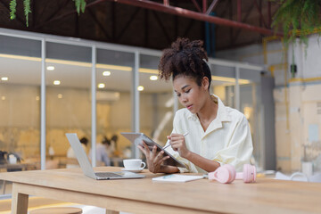 Young African American woman are stressed and tired from work sitting at desk in the office.