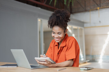 About successful young woman concept. Excited African American woman sitting at working desk.