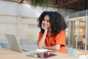 Obraz premium About successful young woman concept. Excited African American woman sitting at working desk.
