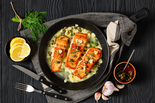 salmon piccata with lemon caper sauce in a pan