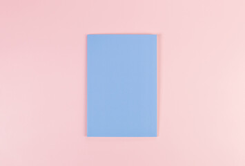 Top view of blue notebook on pink background. School, office wallpaper. Flat lay, copy space.	