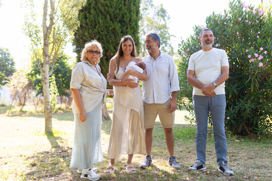 Happy family posing with their newborn baby in the park