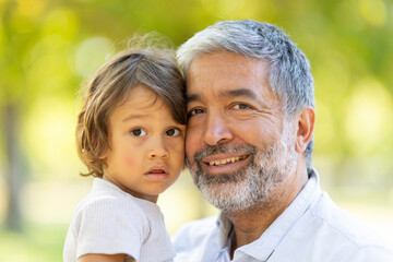 Fototapeta premium Grandfather and grandson posing in the park