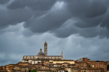 Majestic mammatus clouds above the town of Siena, Tuscany, Italy. Old brick houses under a dramatic looking sky.