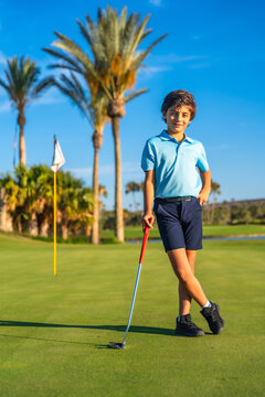Portrait of a boy with golf club standing on course