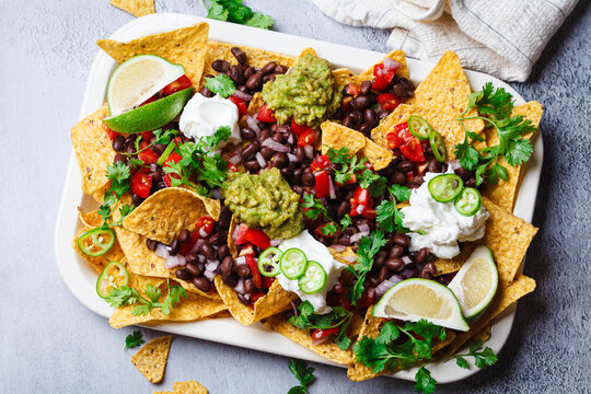 Vegan nachos with guacamole, black beans and salsa for a party.