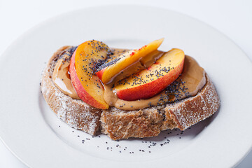Peanut butter toast with peach and seeds.