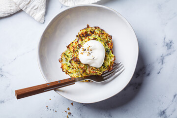 Zucchini pancakes with sour cream.