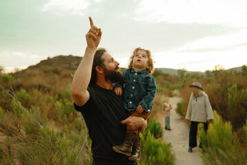 Father points out something in the sky to his child