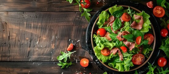 Rustic top view table setting with a delicious appetizer meal of green leaf lettuce tomato and jamon placed on the table with a food background and copy space image