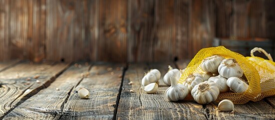 Wooden background sets the stage for a presentation on garlic benefits with a yellow mesh bag in the forefront as a copy space image